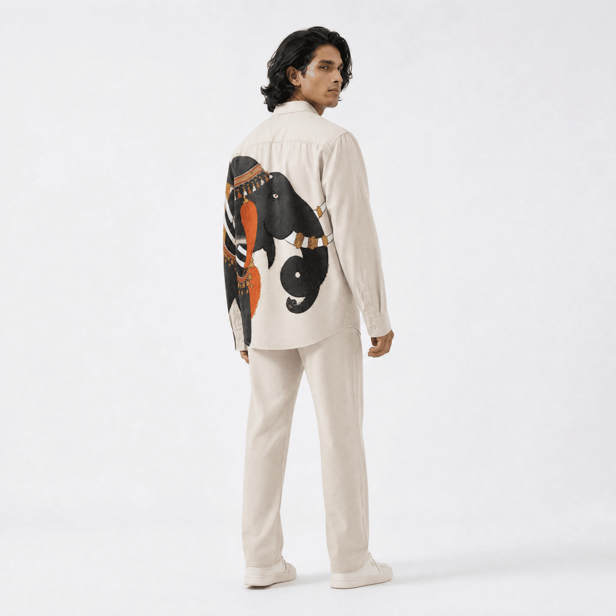Man wearing the ivory Gaj Elephant shirt with cream trousers, full length back view showing the elephant illustration