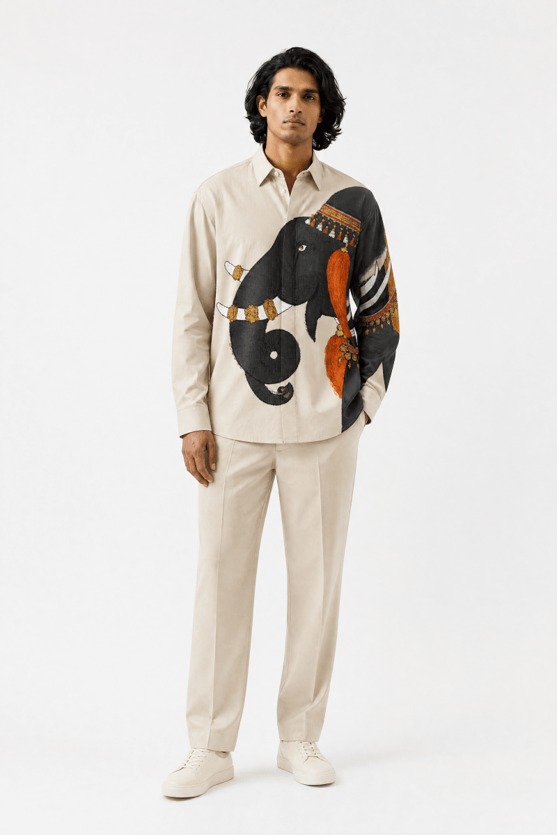 Man wearing the ivory Gaj Elephant shirt with cream trousers, full length front view, hand in pocket