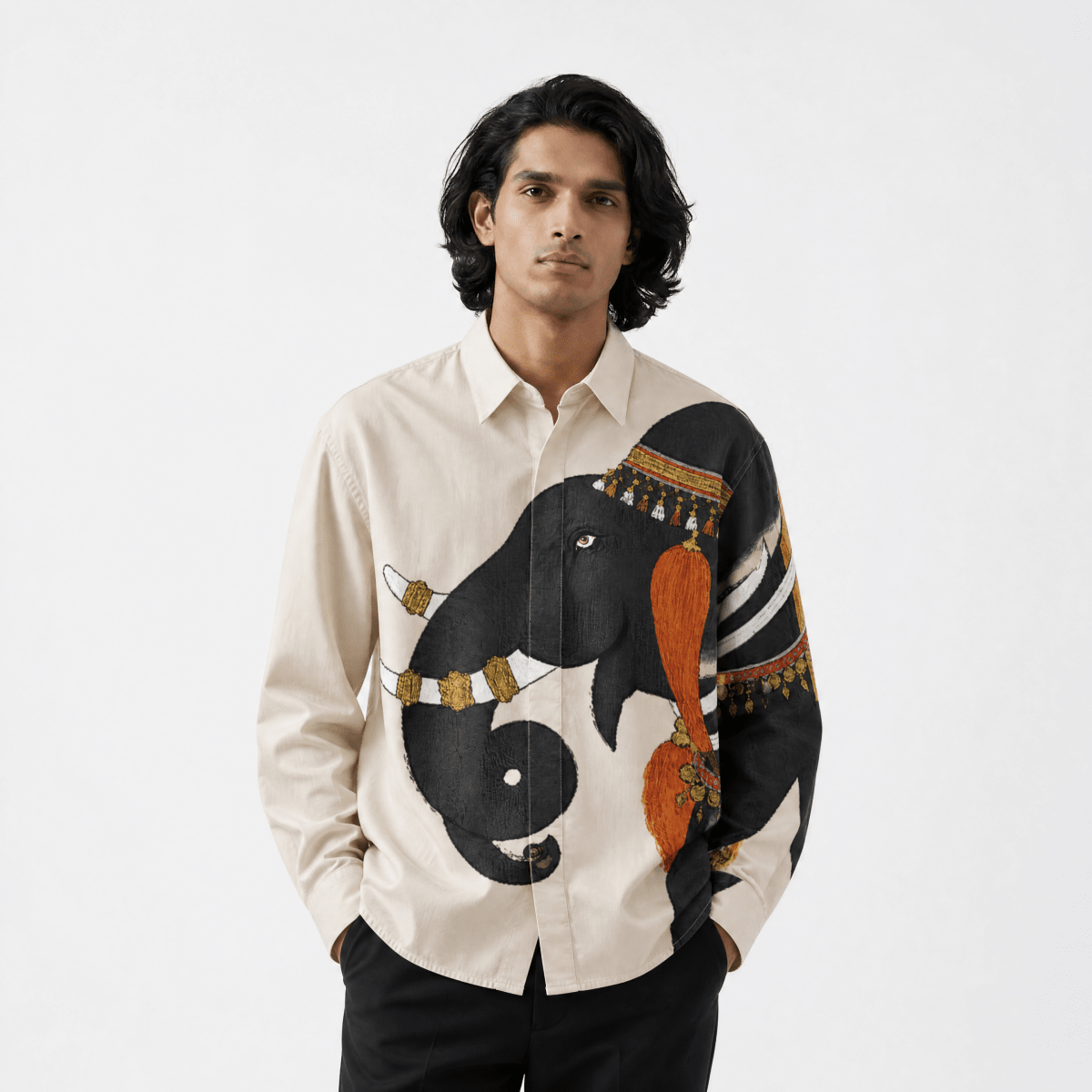 Man wearing the ivory Gaj Elephant shirt with black trousers, front view, hands in pockets