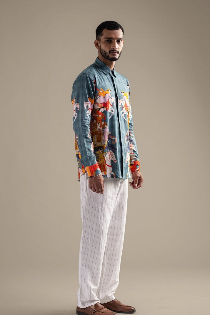 Man wearing the Kirtharjuna shirt with white trousers, full length three-quarter view, looking ahead